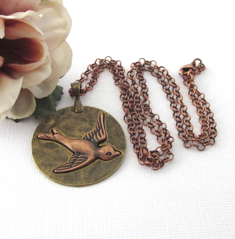 Swallow bird pendant with a 24 inch copper plated rolo style chain. The pendant measures 40 mm by 53 mm including the bail.  A beautiful combination of antique brass and and copper plated. Unisex for both women and men.