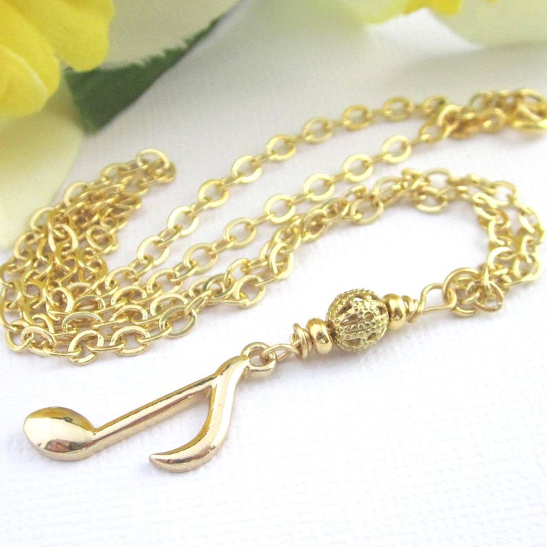 Small gold plated 8th note charm dangles from a gold filigree bead. The full length of the pendant is 1 3/4 inches long.  Comes with a shiny gold plated flat cable chain. Choose 19, 18, or 17 inches long.