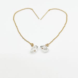 May include: A pair of gold chain earrings with clear crystal teardrop charms.
