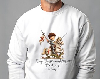 May include: White sweatshirt featuring a cartoon knight on a white horse, holding a flag and sword, with a green dragon below. The text reads "Every Christian is called to fight their dragons. St. George."