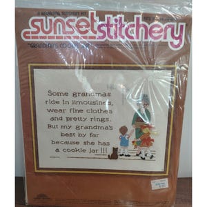 May include: A Sunset Stitchery kit, a beginning stitchery kit, featuring a framed cross-stitch design. The design includes text that reads "Some grandmas ride in limousines...but my grandma's best by far because she has a cookie jar!!!"