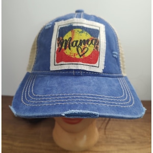 Może przedstawiać: Niebieska czapka bejsbolowa z dżinsu z postrzępionym rondem i beżowym tyłem z siatki. Na przedniej naszywce znajduje się napis "Mama" w ozdobnej czcionce, ze znakiem serca, na tle wzoru baseballowego.