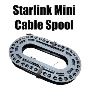 Op de afbeelding: Een grijze Starlink Mini Kabelspoel met de tekst "Starlink Mini Cable Spool" in het zwart. De ovale spoel heeft veel kleine gaten en twee zwarte bandjes. De kabel is zwart.