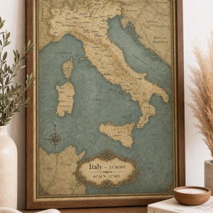 Può includere: Una mappa incorniciata dell'Italia in stile vintage con una tavolozza di colori tenui composta da terre beige e mari blu. La mappa include una rosa dei venti, etichette geografiche dettagliate e un cartiglio decorativo con Italy - Europe 41°54'N 12°30'E.