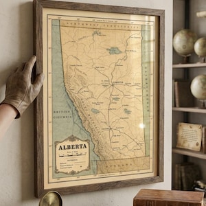 May include: A framed vintage-style map of Alberta, Canada, featuring the text "ALBERTA," "HISTORICAL CARTOGRAPHY," and "RAILWAY HERITAGE SERIES." The map displays geographical details, railway lines, and regional borders in muted tan and green tones.