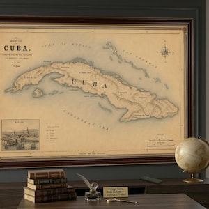 Może przedstawiać: Oprawiona mapa Kuby w stylu vintage z tłem w kolorze sepii, przedstawiająca szczegółową topografię, różę wiatrów oraz wstawkę z ilustracją Hawany. Mapa zawiera etykiety tekstowe miast i cech geograficznych w ciemnej drewnianej ramie.