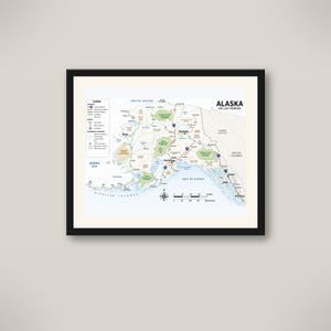 以下が含まれることがあります： 「Alaska The Last Frontier」と題されたアラスカの額入り地図。凡例、方位磁針、キロメートル単位の縮尺が記載されています。地図には主要な高速道路、アンカレッジやフェアバンクスなどの都市、国立公園、周辺の海域が示されています。