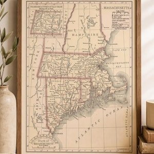 May include: A framed vintage-style map of Massachusetts and the Berkshire and Connecticut Valley region, printed in beige and black with pink borders. The map includes a scale of miles, a grid system, and labels for cities, counties, and the Atlantic Ocean.