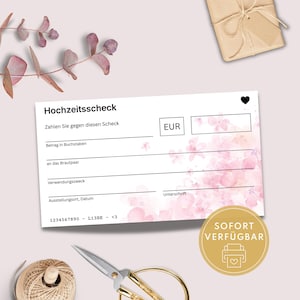 Könnte beinhalten: Ein weißer Hochzeitscheck mit rosa floralen Akzenten und dem Text "Hochzeitsscheck". Der Scheck enthält Felder für den Betrag, den Empfänger, den Zweck und das Datum. Ein goldener Aufkleber mit dem Text "SOFORT VERFÜGBAR".