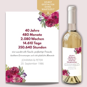 Op de afbeelding: Een fles witte wijn met een aangepast etiket in het Duits, met tekst als "40 Jahre" en de namen Johanna & Peter. Het etiket is versierd met bordeauxrode bloemaccenten.