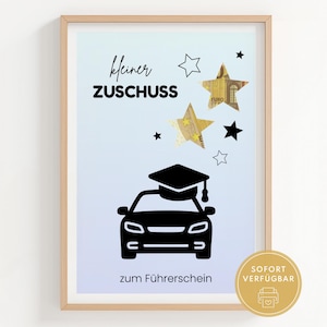 Puede incluir: Impresión enmarcada con un fondo degradado azul claro. La impresión presenta un coche negro con un gorro de graduación, estrellas y texto en alemán. Una pegatina dorada con texto está en la esquina inferior derecha.