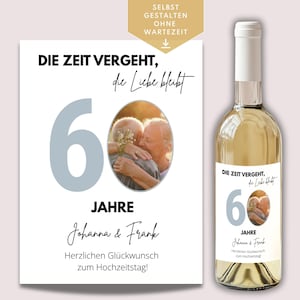 Puede incluir: Una botella de vino blanco y una impresión a juego que celebra el 60 aniversario de bodas. La impresión y la etiqueta de la botella presentan el texto "Die Zeit vergeht, die Liebe bleibt" y los nombres "Johanna & Frank".