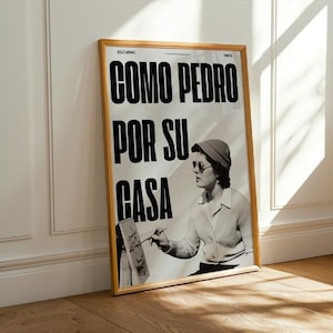 May include: A black and white poster with the text "COMO PEDRO POR SU CASA" in bold black letters. A woman wearing a hat and glasses is painting in the background.