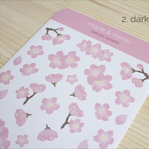 Pode incluir: Uma folha de adesivos de flores de cerejeira rosa e branca com o texto "maple & matsu sakura season" e "2. dark pink".