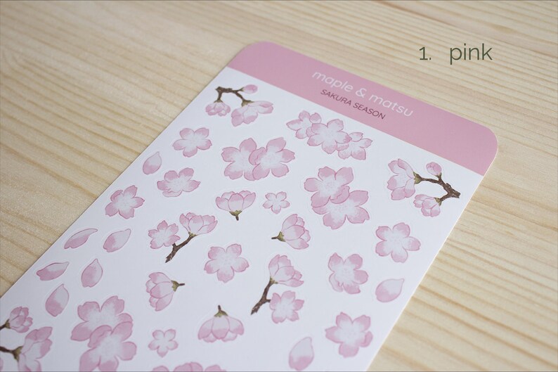 Pode incluir: Uma folha de adesivos rosa com ilustra&ccedil;&otilde;es de flores de cerejeira e p&eacute;talas. A folha &eacute; etiquetada como "maple & matsu" e "sakura season".