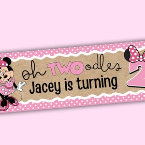 K&ouml;nnte beinhalten: Ein rosa-braunes Banner mit dem Text "oh TWOodles Jacey is turning". Das Banner zeigt eine Cartoon-Figur von Minnie Mouse und eine gro&szlig;e rosa Zahl 2. Das Banner ist mit einem rosa Polka-Dot-Rand verziert.