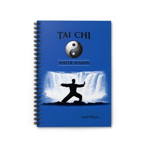 以下が含まれることがあります： 青い表紙に「TAI CHI」の文字と陰陽のシンボルが描かれた、スパイラル綴じのノート。下には「WATER SEASON」の文字と、滝の前で太極拳をする人のシルエットが描かれています。