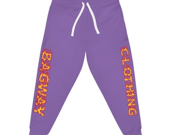 May include: Purple sweatpants with a white drawstring. The words "BAGWAY CLOTHING" are printed vertically down the sides in a fiery orange and yellow font. The pants are made of a soft material.