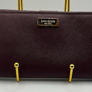 Una billetera Kate Spade New York con broche de presión en piel color burdeos HTF muy poco común