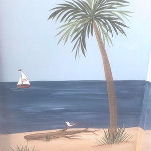 May include: A hand-painted mural depicting a tropical beach scene with a palm tree, a sailboat, a seagull perched on a driftwood log, and blue water. The mural is painted on a light blue background.