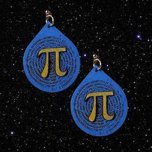 Puede incluir: Un par de pendientes azules en forma de lágrima con símbolos pi dorados y los dígitos de pi que rodean los símbolos.
