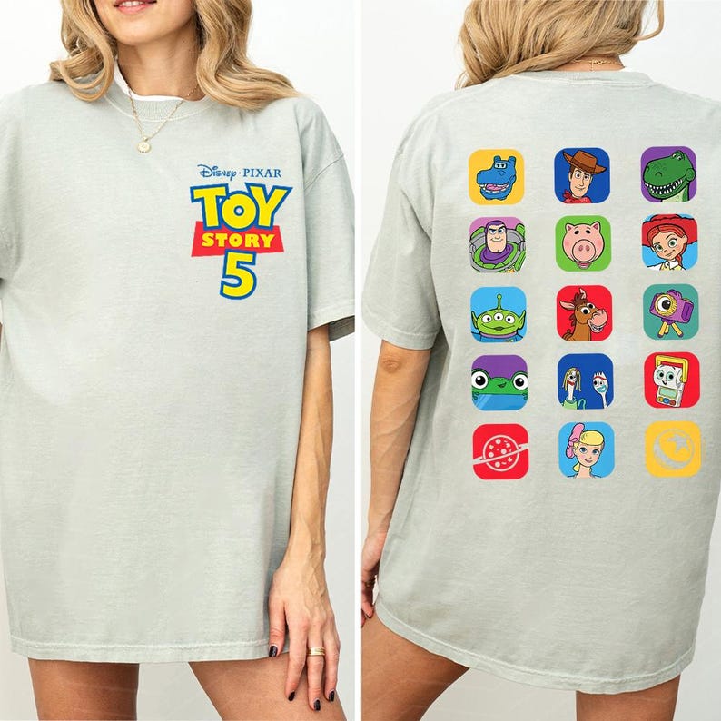 May include: A light gray short-sleeve t-shirt featuring the Disney Pixar Toy Story 5 logo on the front chest. The back of the shirt displays a grid of fifteen colorful square icons, each containing a different character or symbol from the film series.