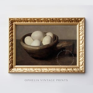 May include: A painting of a wooden bowl filled with white eggs, set against a dark brown background. The bowl is in focus, while the background is blurred. The painting is framed in a gold frame.