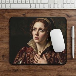 Könnte beinhalten: Eine schwarze Mausunterlage mit einem Renaissance-Porträt einer Frau mit betrübtem Gesichtsausdruck. Sie trägt ein bordeauxrotes und goldfarbenes besticktes Kleid, eine Perlenkette und ein goldenes Diadem. Eine weiße Maus, Tastatur und Stift sind ebenfalls zu sehen.