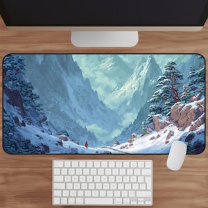 May include: A rectangular mouse pad featuring a snowy mountain landscape with a person in a red coat. The design includes snow-covered trees, a winding path, and a valley with towering peaks. A white keyboard and mouse are visible.