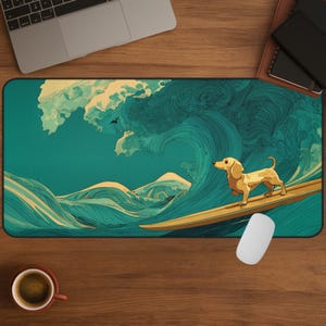 May include: A rectangular mousepad featuring a dachshund dog surfing a large ocean wave. The wave is teal and turquoise, with a yellow surfboard. The dog is light brown. A laptop, coffee cup, and other items are in the background.