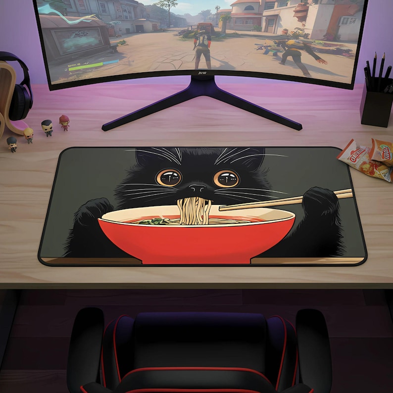May include: A rectangular mousepad featuring a black cat eating ramen from a red bowl. The cat's face and paws are visible, with chopsticks holding up noodles. The background is a muted green.