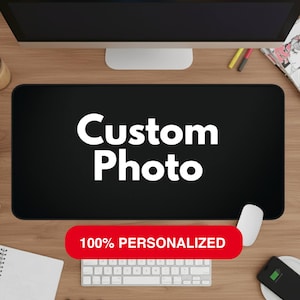 May include: Black rectangular mouse pad with the words "Custom Photo" in white. A red banner at the bottom reads "100% PERSONALIZED". A white mouse, keyboard, and phone are also visible.