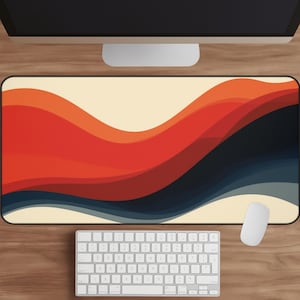 May include: A rectangular desk mat with a retro wave design in shades of orange, red, and navy blue. The mat sits on a wooden desk, with a white keyboard and mouse visible. The design features a cream-colored background.