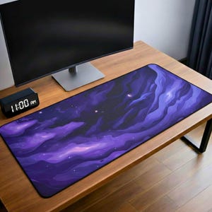 Puede incluir: Alfombrilla de escritorio rectangular con un diseño de nebulosa púrpura y azul. La alfombrilla presenta un fondo oscuro con nubes arremolinadas y estrellas. La alfombrilla está sobre un escritorio de madera, con un monitor de computadora y un reloj digital visibles.