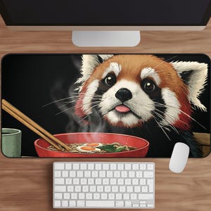 May include: A rectangular mouse mat with a red panda design. The panda is looking at a bowl of ramen with noodles, eggs, and greens. Chopsticks and a green cup are also present. The background is black.