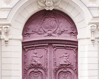 May include: A pair of ornate, double doors with intricate carvings and a deep purple paint finish. The doors are set within a white archway with a decorative stone element above.