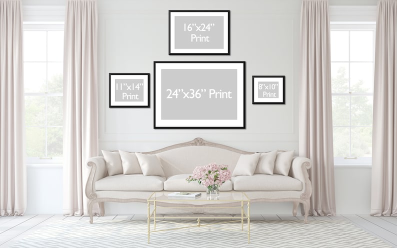 May include: A living room scene featuring framed prints of various sizes: 8x10 inches, 11x14 inches, 16x24 inches, and 24x36 inches. The prints are displayed above a cream-colored sofa with decorative pillows. The room has light-colored curtains and a patterned rug.