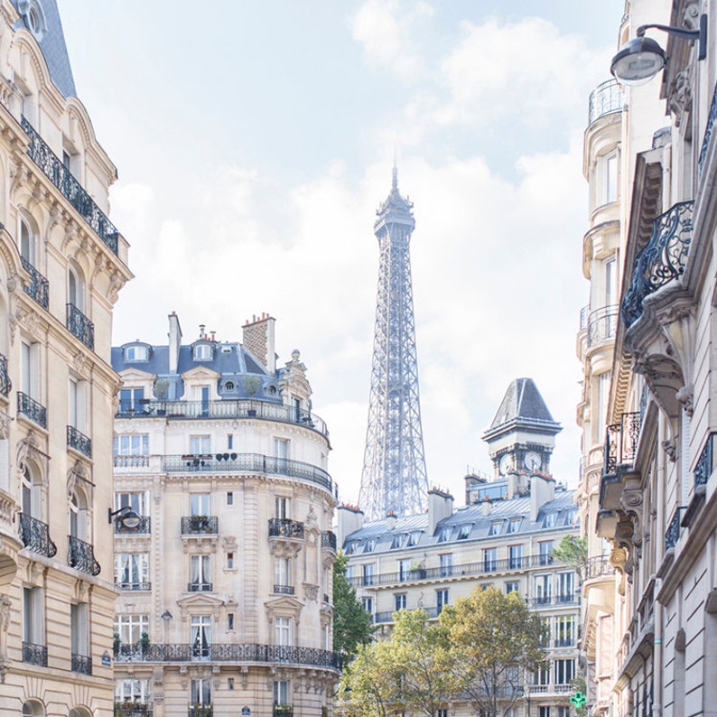 May include: A view of the Eiffel Tower from a narrow street in Paris, France. The tower is visible in the distance, with buildings lining the street on either side.
