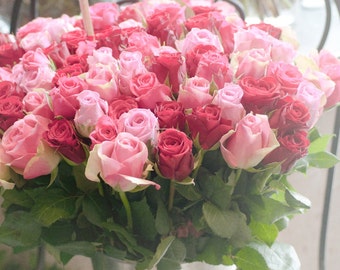 May include: A bouquet of pink and red roses in a silver bucket. A sign reads "Roses Modernes" with prices for 1, 11, 45, and 1 rose.