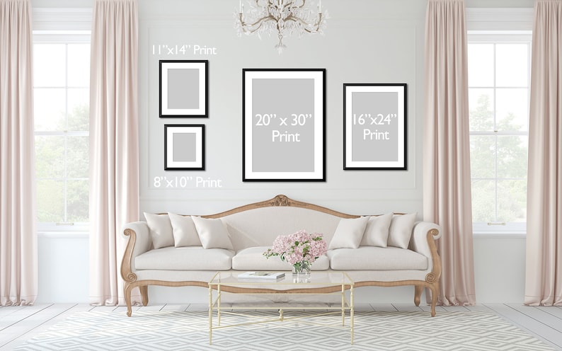 May include: A white sofa with pillows sits in front of a white wall with four black framed prints. The prints are of different sizes and have the dimensions 11"x14", 8"x10", 20"x30", and 16"x24" printed on them.
