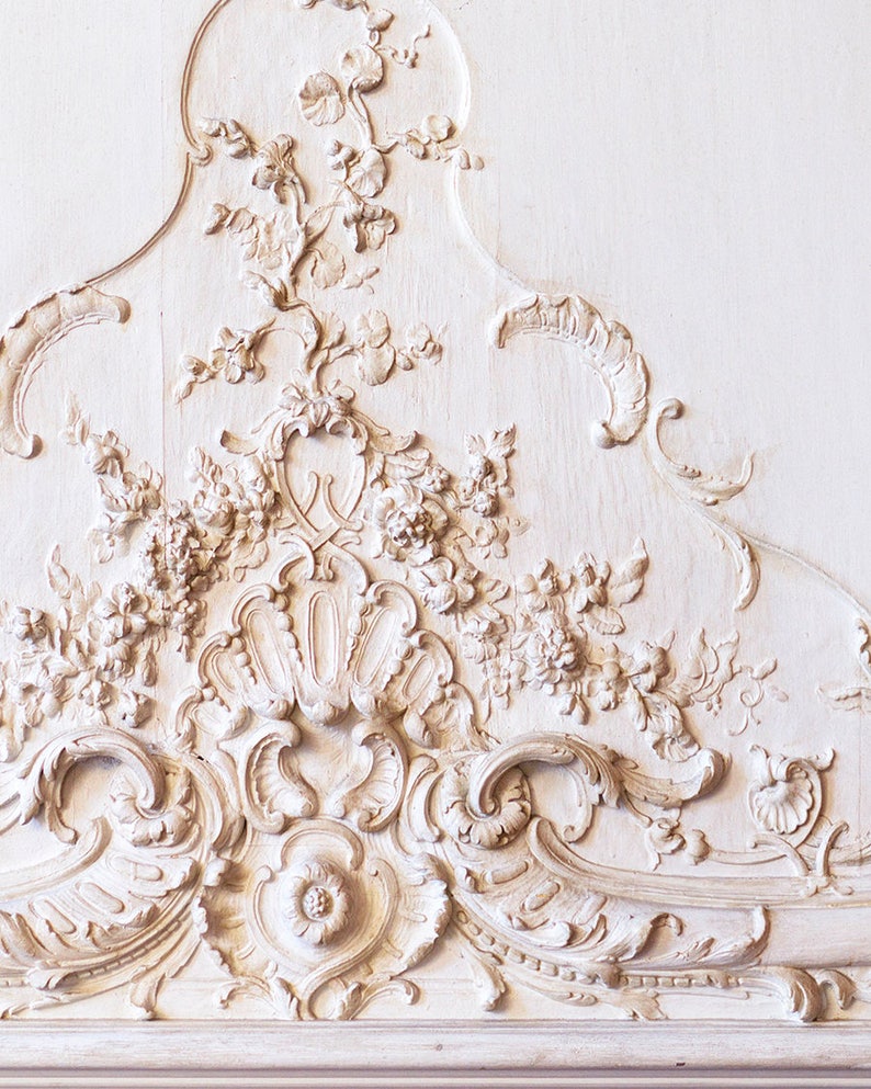Puede incluir: Talla de madera ornamentada pintada de blanco con un dise&ntilde;o floral. La talla es de estilo rococ&oacute; y presenta detalles intrincados.