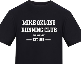 May include: Black t-shirt with the text "MIKE OXLONG RUNNING CLUB" in white block letters. Below the club name is the phrase "WE GO HARD" and "EST 1969". The shirt is a crew neck style.