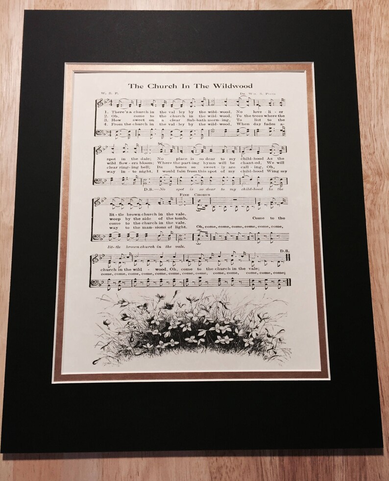 May include: A vintage sheet music page titled "The Church In The Wildwood". The sheet music includes the lyrics and musical notation for the song. The page is decorated with a black and white illustration of a cluster of flowers.