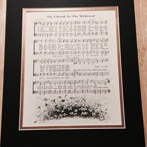May include: A vintage sheet music page with the title "The Church In The Wildwood" and lyrics for the song. The sheet music features a black and white illustration of a small cluster of flowers in a field.