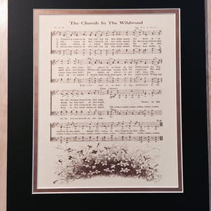 May include: A vintage sheet music page titled "The Church In The Wildwood". The sheet music is printed in brown ink on cream-coloured paper. The music features a drawing of a church in the woods with flowers and leaves.