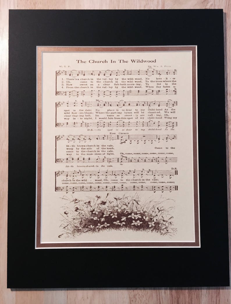May include: A vintage sheet music page titled "The Church In The Wildwood". The sheet music is printed in brown ink on cream-coloured paper. The music features a drawing of a church in the woods with flowers and leaves.