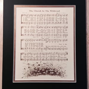 May include: A vintage sheet music print of the song "The Church In The Wildwood". The sheet music is printed in brown ink on cream-coloured paper. The lyrics and musical notes are visible. The image also includes a small illustration of a cluster of flowers at the bottom of the page.