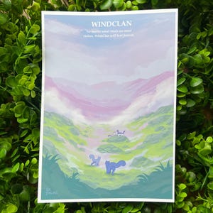 May include: A print depicting a landscape with a blue sky, pink and purple mountains, and green hills. The text "WINDCLAN" is at the top, with the quote "No matter what trials we must endure, WindClan will last forever." Two blue cat-like figures are in the foreground.