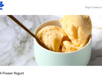 May include: A close-up of peach frozen yogurt in a light blue bowl with a gold spoon. The frozen yogurt is a light orange color and has a soft, creamy texture. The bowl is sitting on a white and gray marble surface.