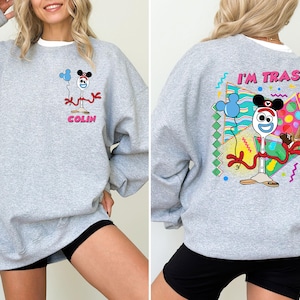 May include: Grey sweatshirt with a cartoon character on the front and the text "I'm Trash" and a cartoon character on the back.